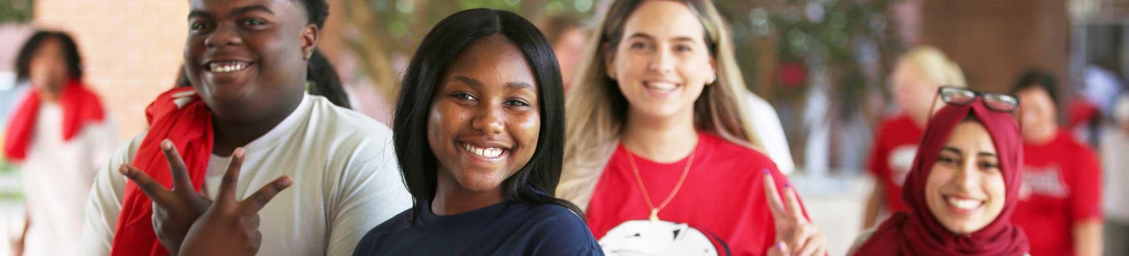 Four USA students smiling and walking outside.