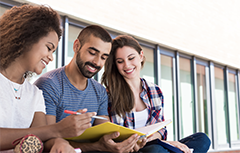 Three students looking at book